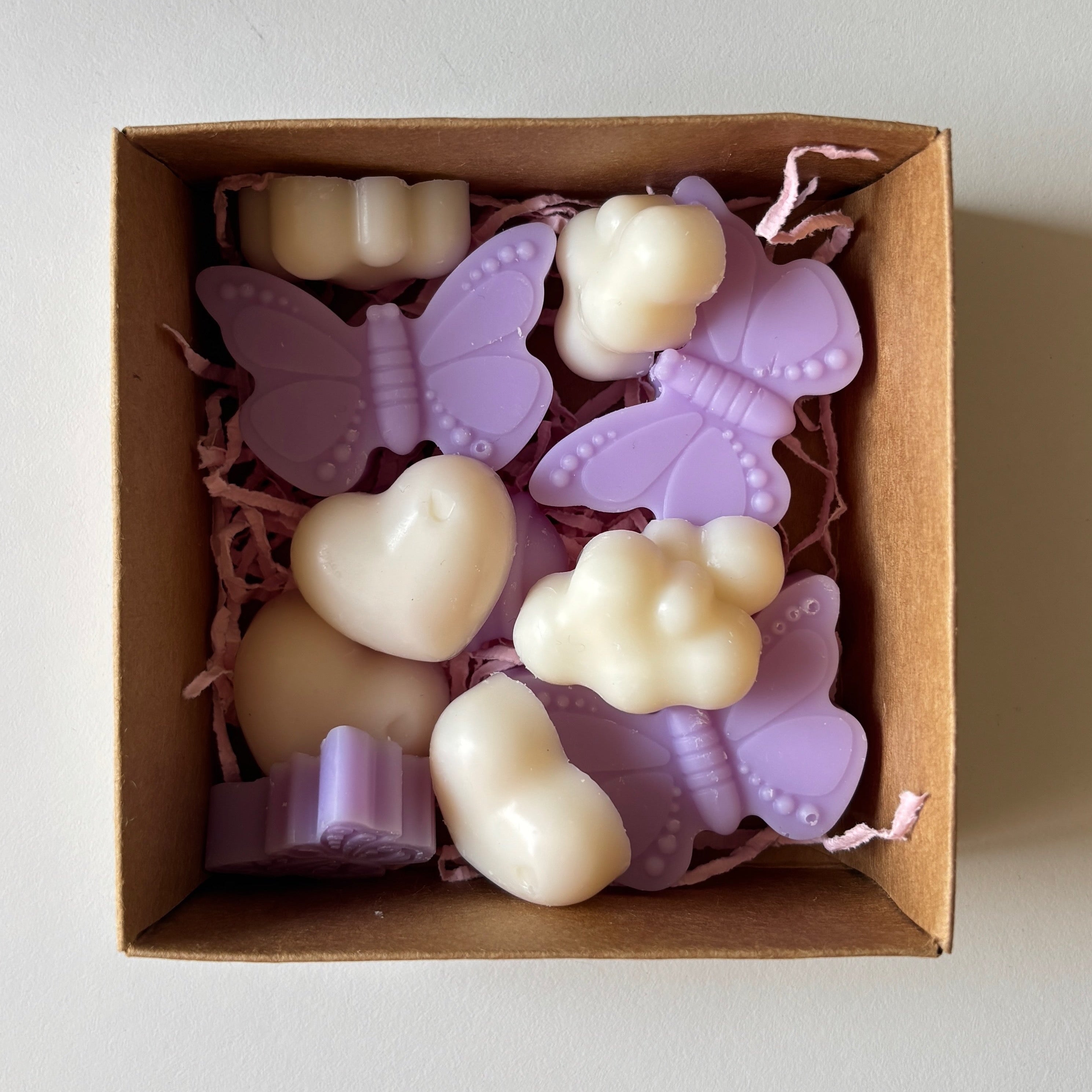 Box of butterfly-shaped candles on a light background