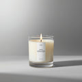 White sandalwood candle in a glass jar on a gray background